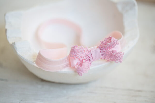 Dětská čelenka na&nbsp;gumce s&nbsp;krajkovou mašlí – růžová